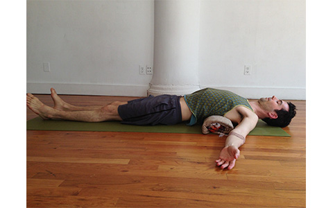 Photo: Man demonstrates Restorative Backbend yoga pose