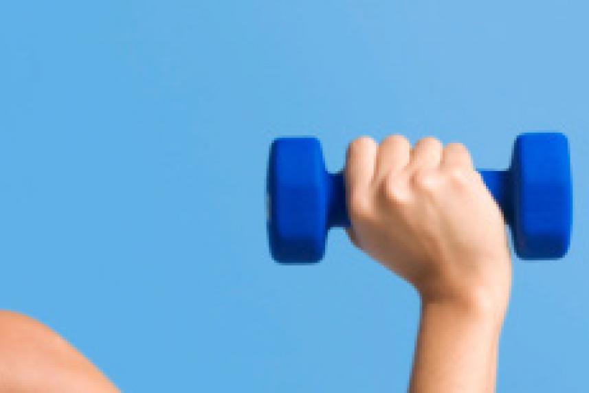 Photo: Fit woman pushing dumbbell over head
