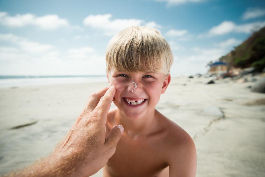 Dad applying sunscreen to son