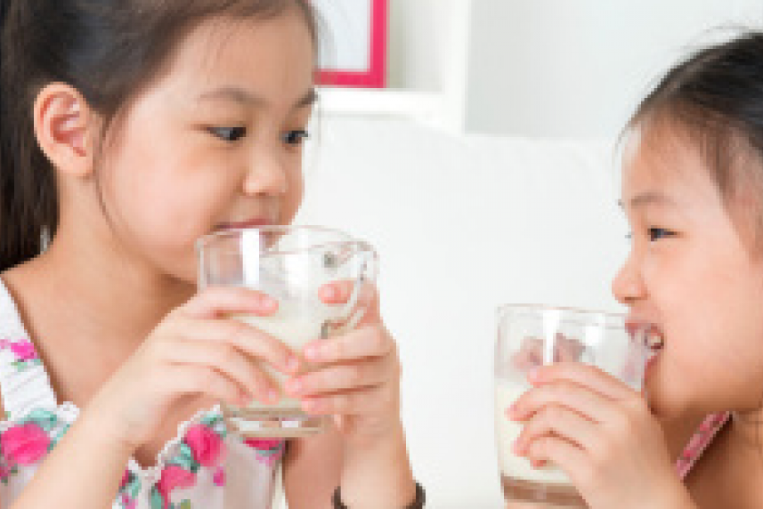 Photo: Two young girls drinking glasses of milk