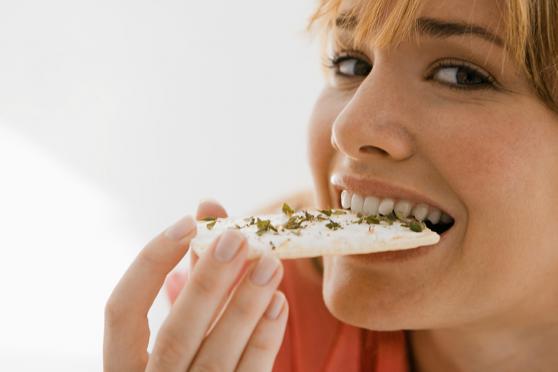 Photo: Woman biting into a cracker