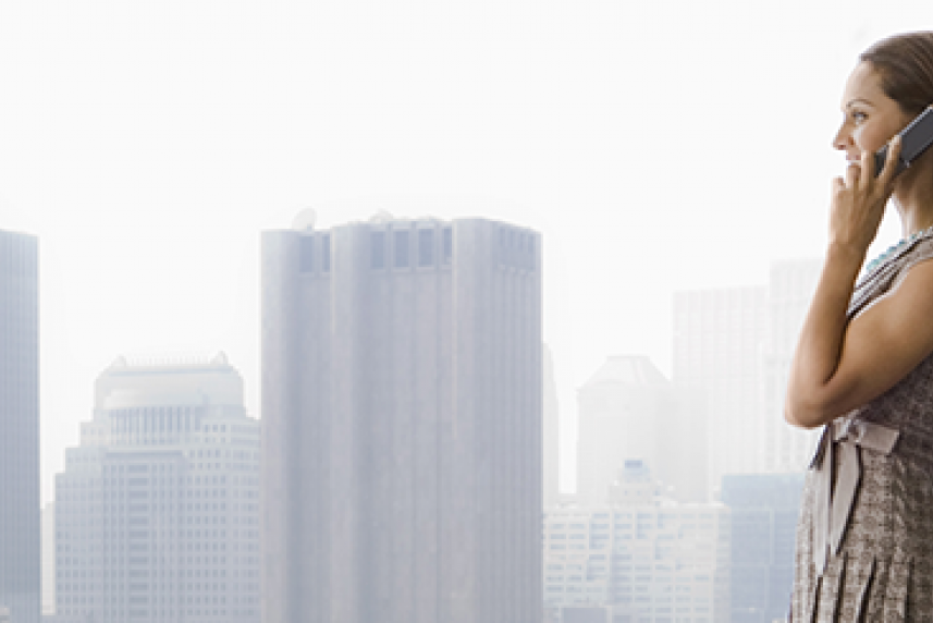Photo: Woman on phone looking out over city