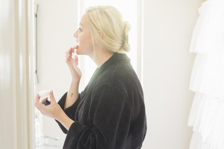 woman putting on chapstick