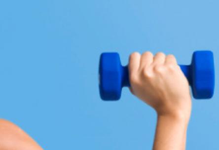 Photo: Fit woman pushing dumbbell over head