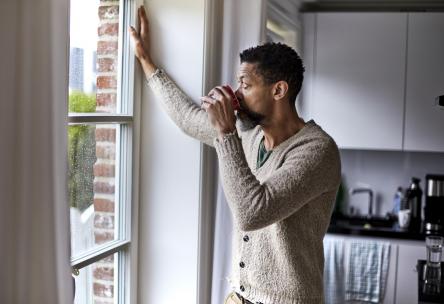 Man looking out the window anxiously