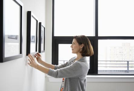 woman hanging up art