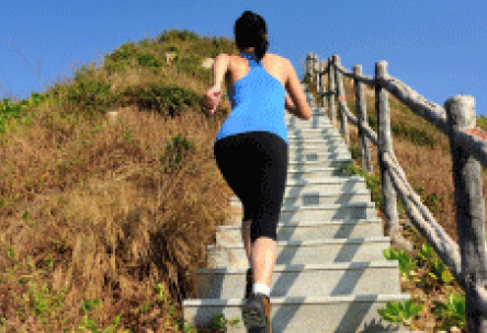 Photo: Fit woman running up a long set of outdoor stairs on a mountain