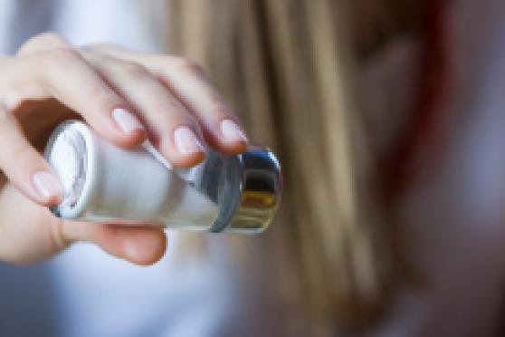 Photo: Woman's hand holding a salt shaker