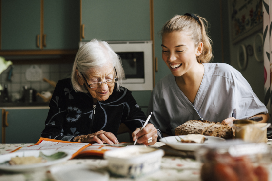 Image of older and younger woman sitting in kitchen together