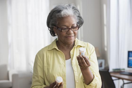 Older woman reading the label on her cholesterol prescription