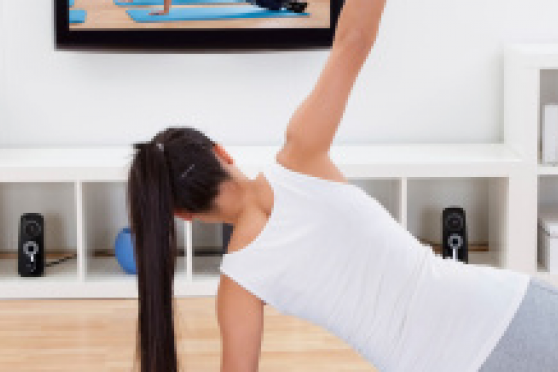 Photo: Woman doing an at-home workout in front of television