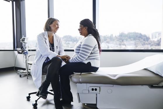 A woman and her doctor talk during her annual wellness visit. 